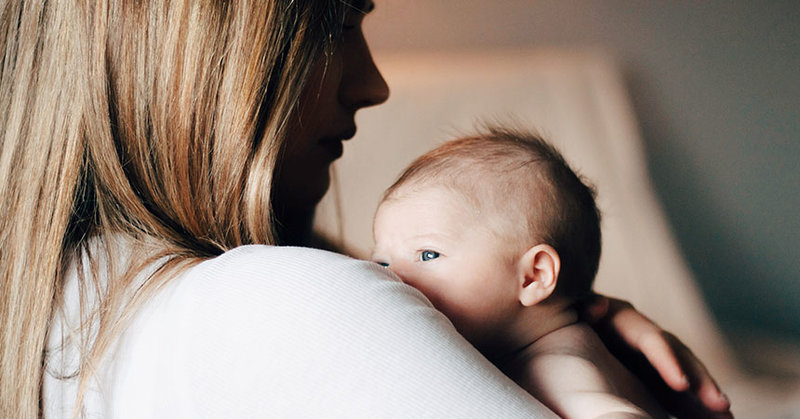 Frau hält Baby auf dem Arm