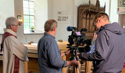 Die Kameraleute Danny Podeus (Mitte) und Alex Meyer bei der Arbeit, Pastor Petersen schaut zu - Copyright: Marlene Freese