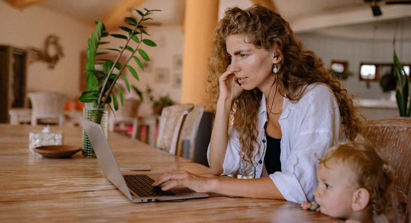 Frau mit Kind vor Notebook