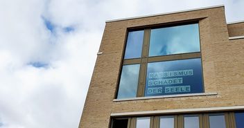 Haus der Kirche großes Fenster, Schriftzug Rassismus - Copyright: © Hagen Grützmacher